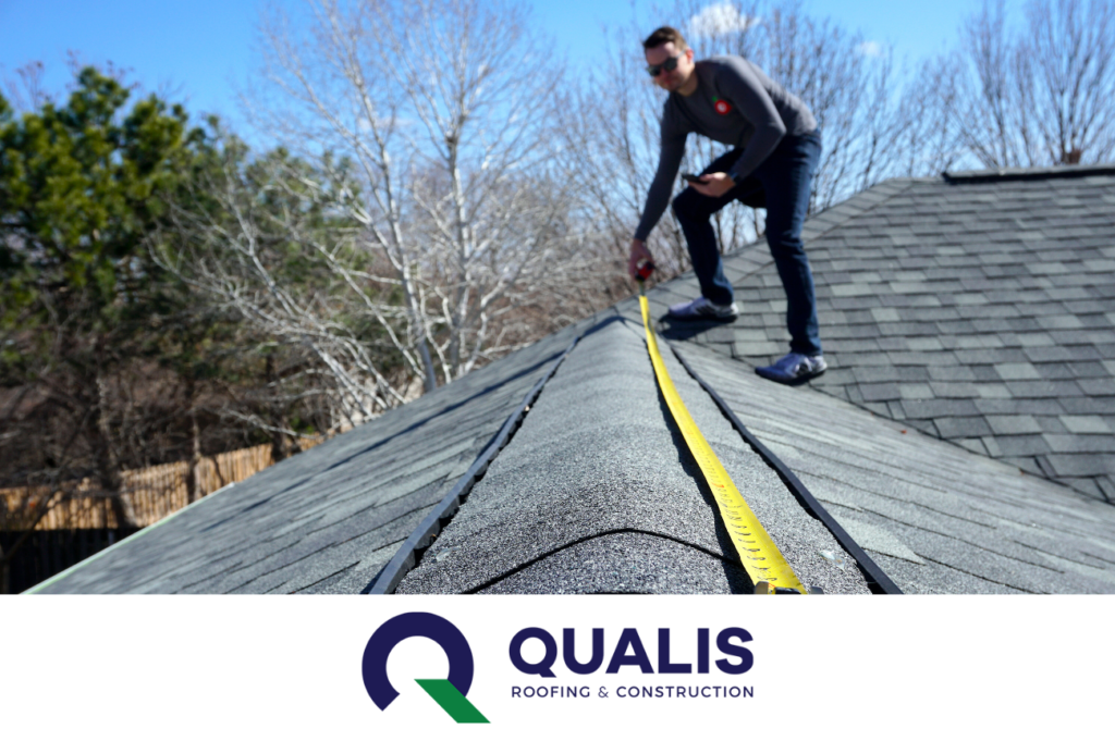 A person measures the length of a roof with a yellow tape measure on a sunny day. The "Qualis Roofing & Construction" logo is visible at the bottom, ensuring you make the right choice for any roof repair needs.